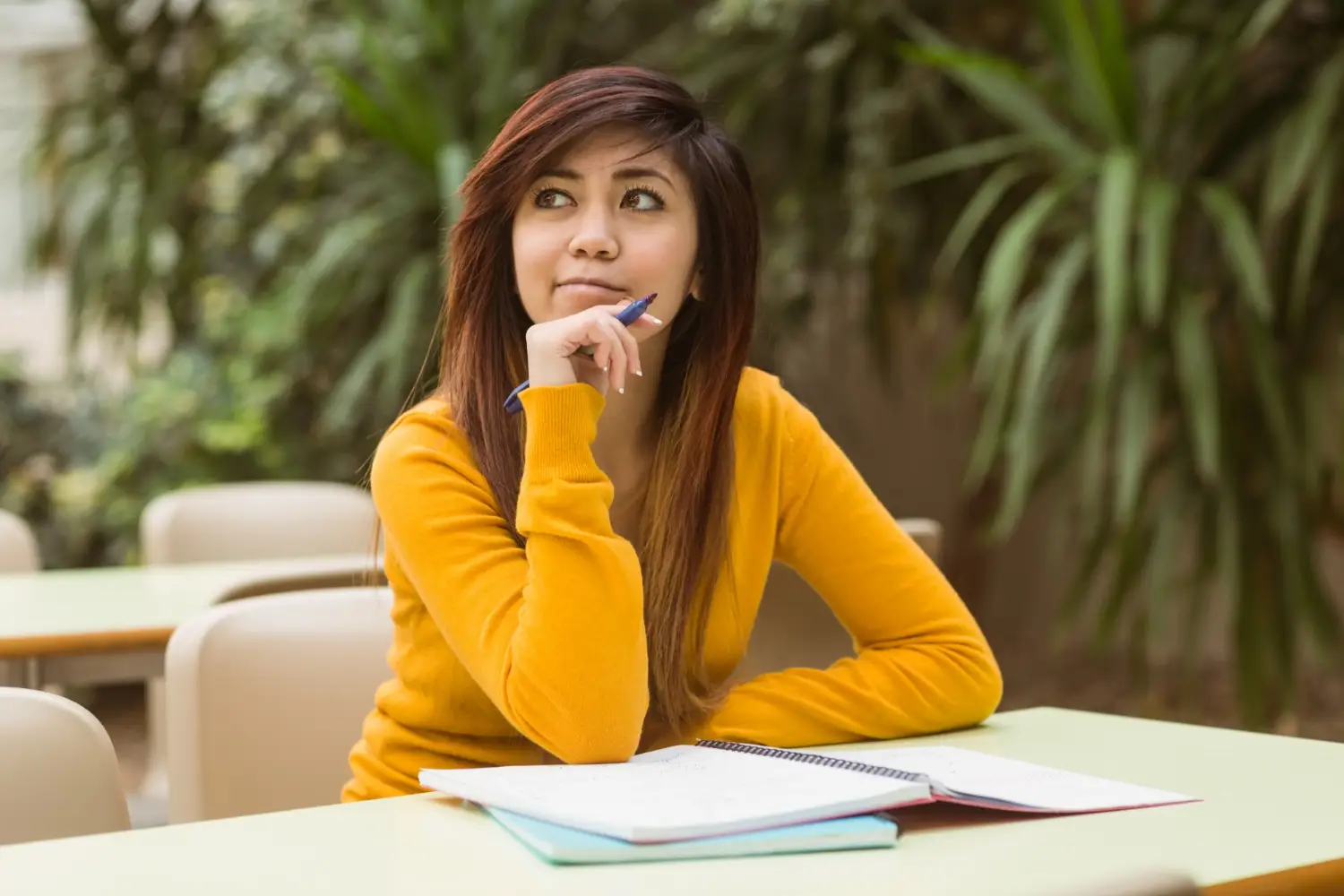 Student preparing for high IELTS band score, holding a pen and notebook